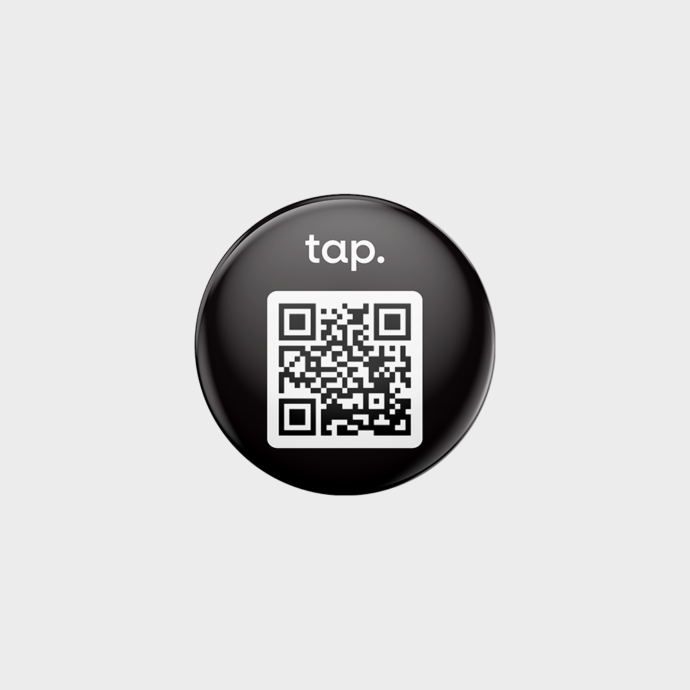 Round black QR code sticker with logo on glossy surface