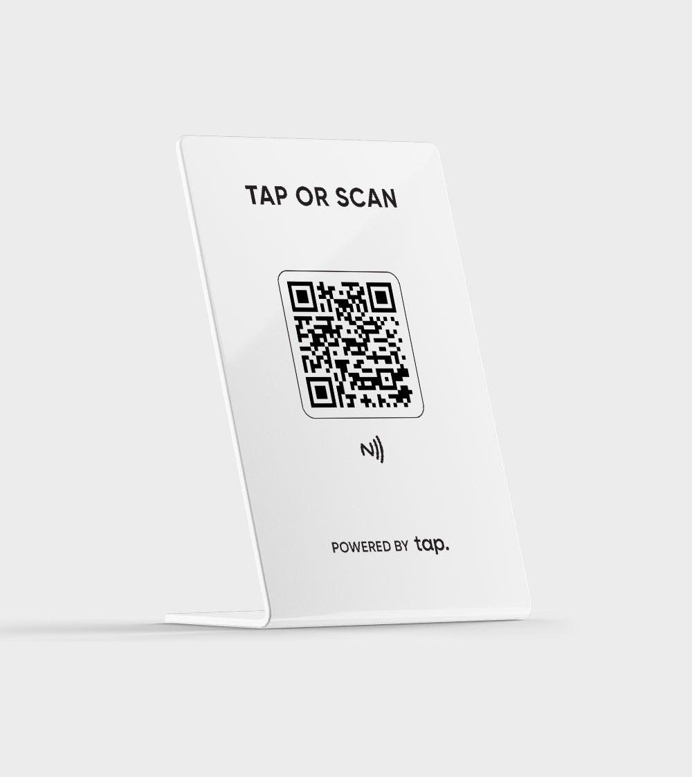 White NFC card stand with QR code and 'TAP OR SCAN' text, powered by Tap technology."