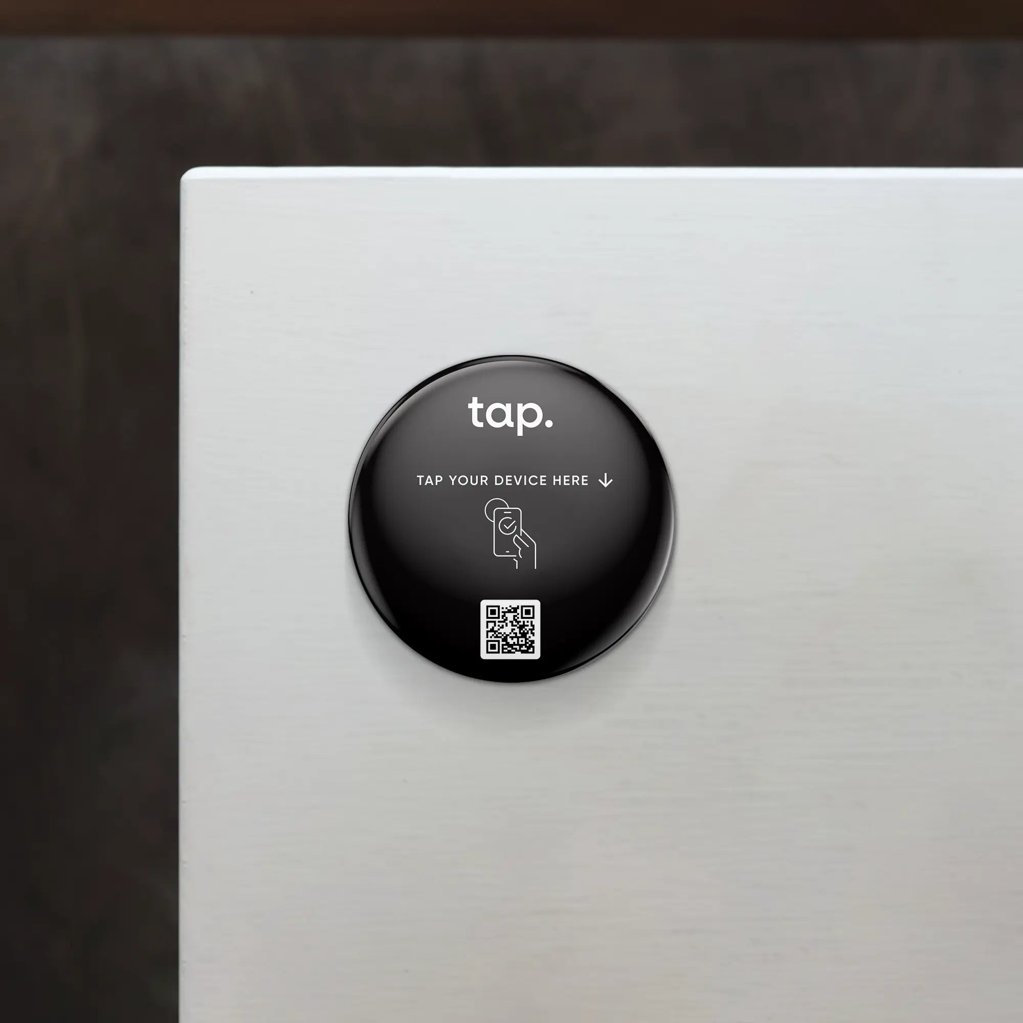 NFC payment sticker with a 'tap' sign and QR code on a white surface.