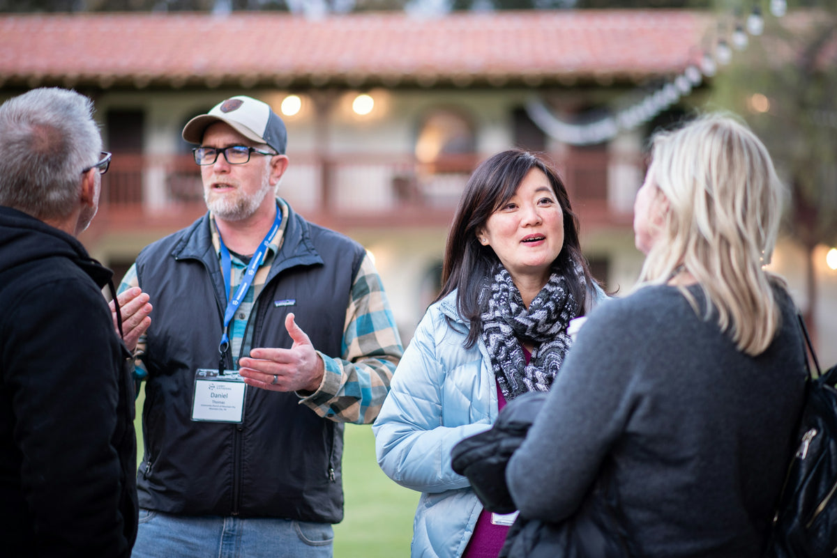 People with event badges talking at a conference