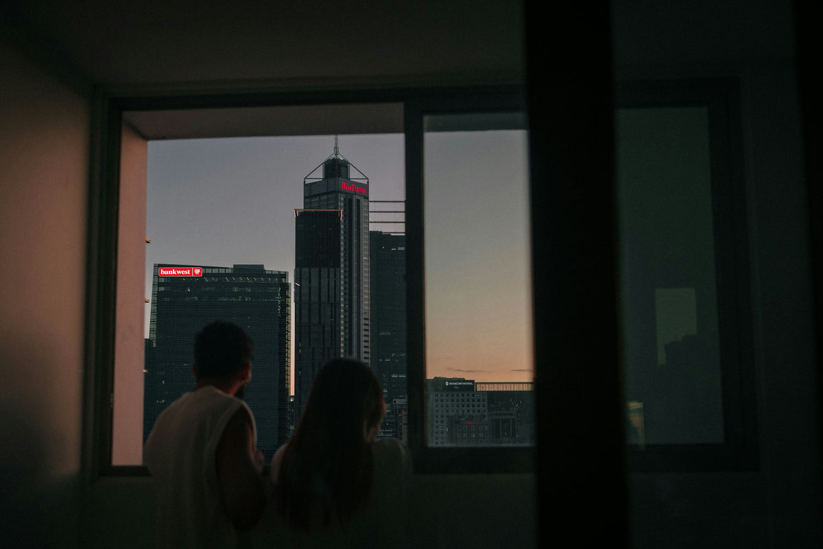 Two buyers looking at the city from an apartment window