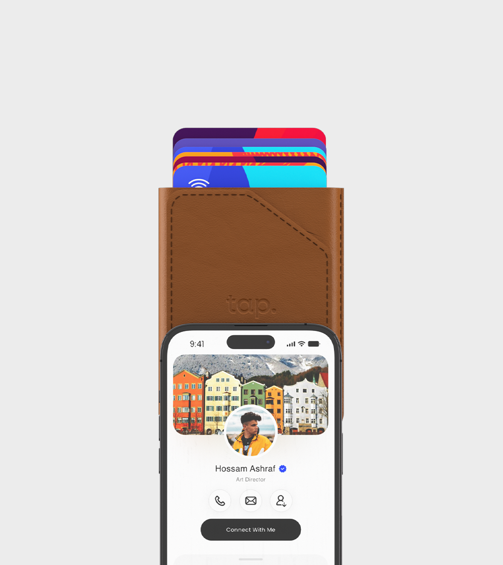 Digital business card app on smartphone screen above a leather wallet with colorful cards.